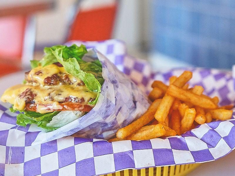 Taco Burger de El Bajón: doble carne con queso derretido y lechuga en tortilla de harina, con papas.